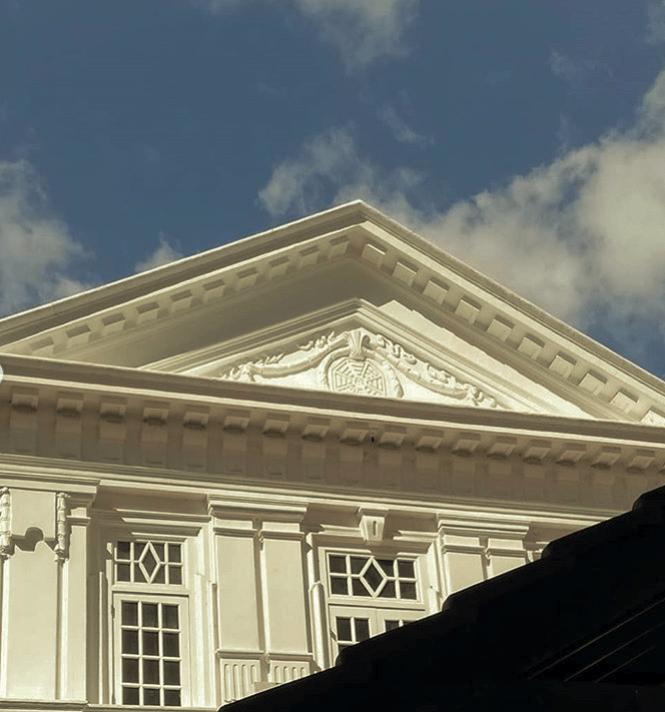 Architectural detail of the facade of a white mansion.