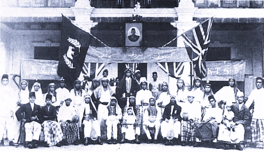 Kumpulan Troupe Sharghi Boria troupe in front of flags.