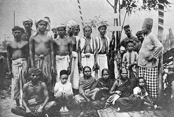 A black and white photo of local people in Penang. There is a mix of men, women and children.