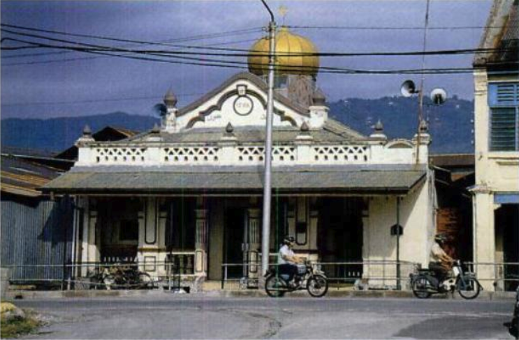 Photo of a building with a white facade and an awning.