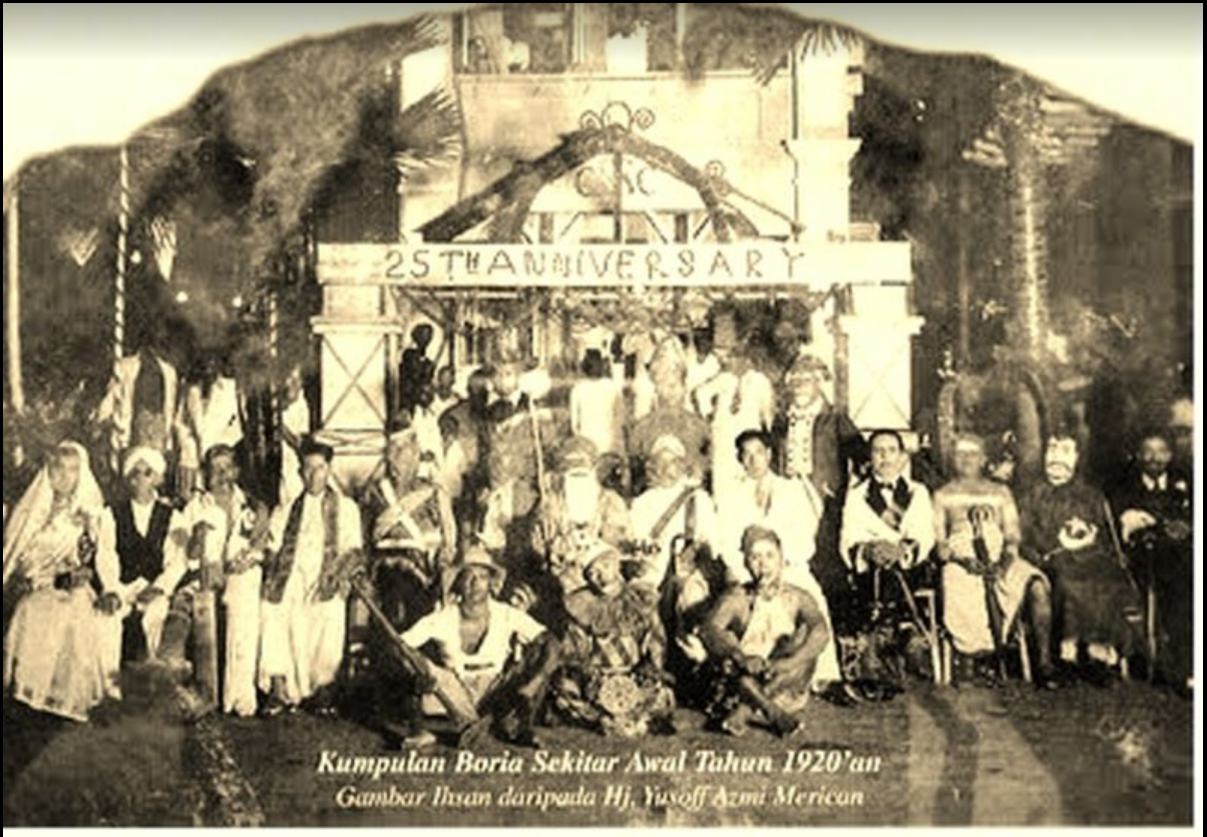 Large group sitting under a 25th Anniversary sign