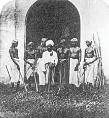 A black and white photograph of convicts with tools for working the land.