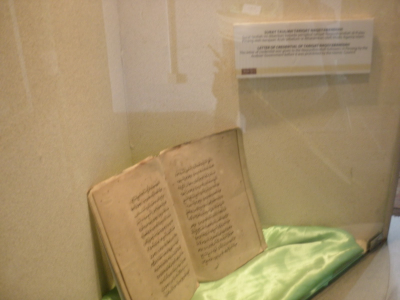 An open book on display in a museum.