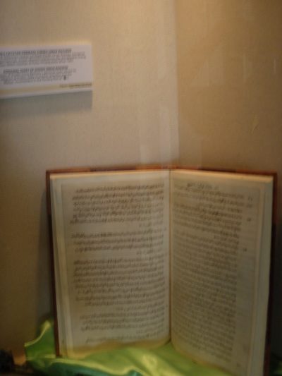 An open book on display in a museum.