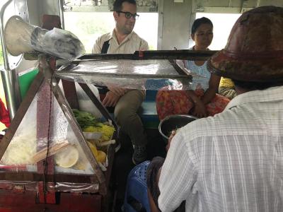 A man selling food from a mobile store on the train.