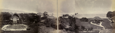 Panoramic black and white photograph showing three large homes overlooking the water.