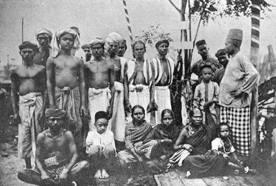 A black and white photo of local people in Penang. There is a mix of men, women and children.