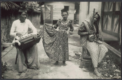 Black and white photo of two musicians and a young girl, the dancer, in the middle.